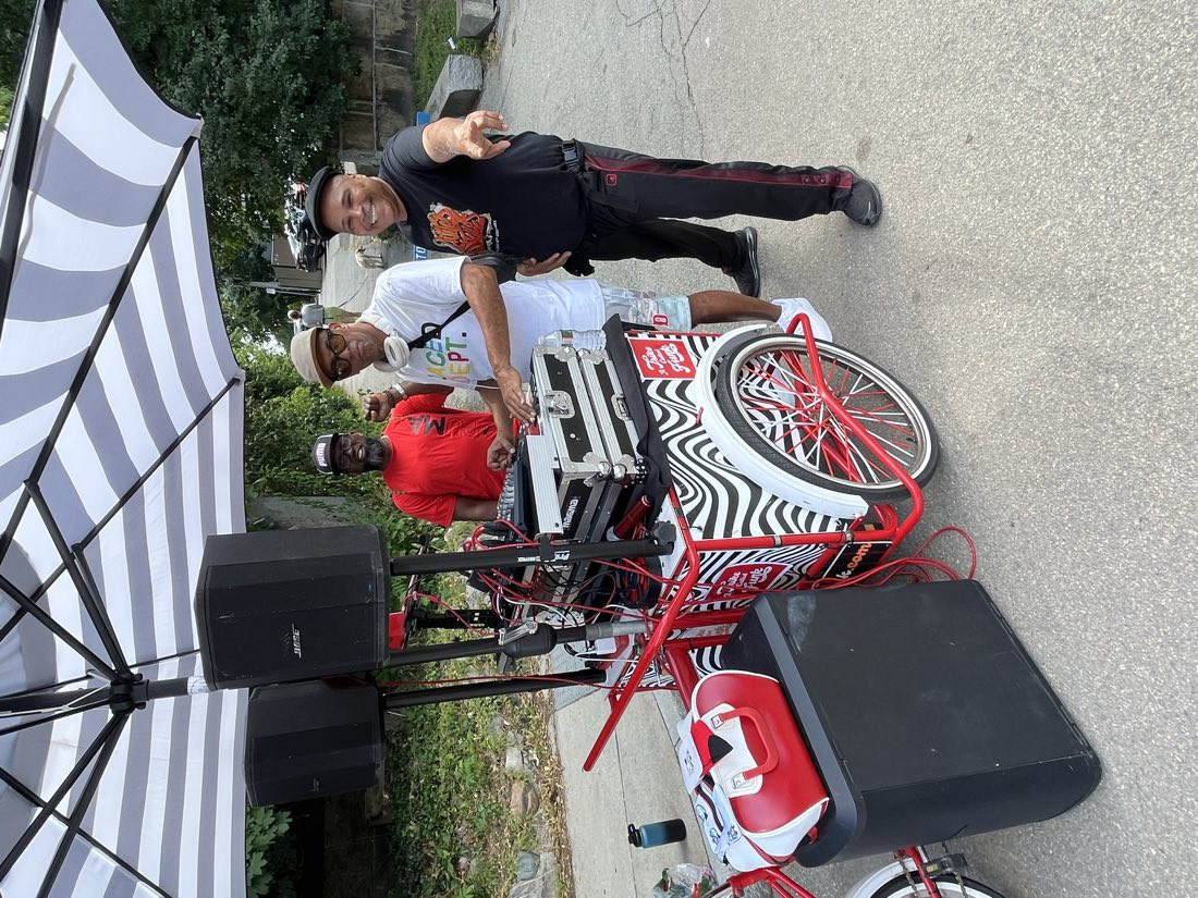 DJ Leanskee at an outdoor street DJ cart with the crew