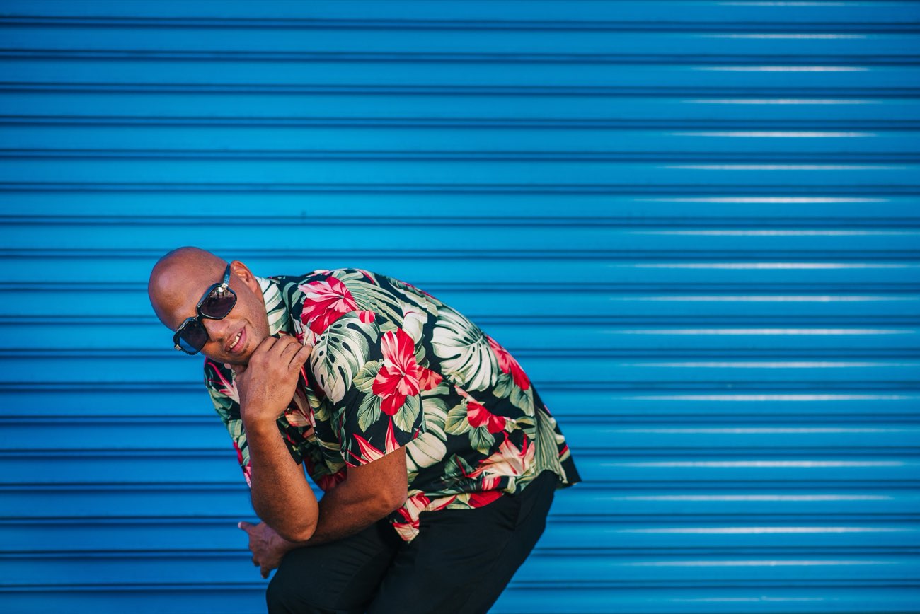 DJ Leanskee portrait in a floral aloha shirt against a blue wall